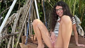 When no one is looking, a woman wearing glasses urinates loudly while sitting on a swing.