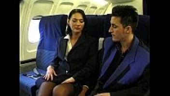 On a plane, a brunette beauty in a hostess costume is adored.