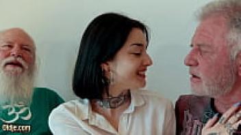 A young brunette eats sperm while in a threesome with elderly males.