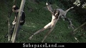 Outdoors, a hairy, nude pussy is tied and whipped.